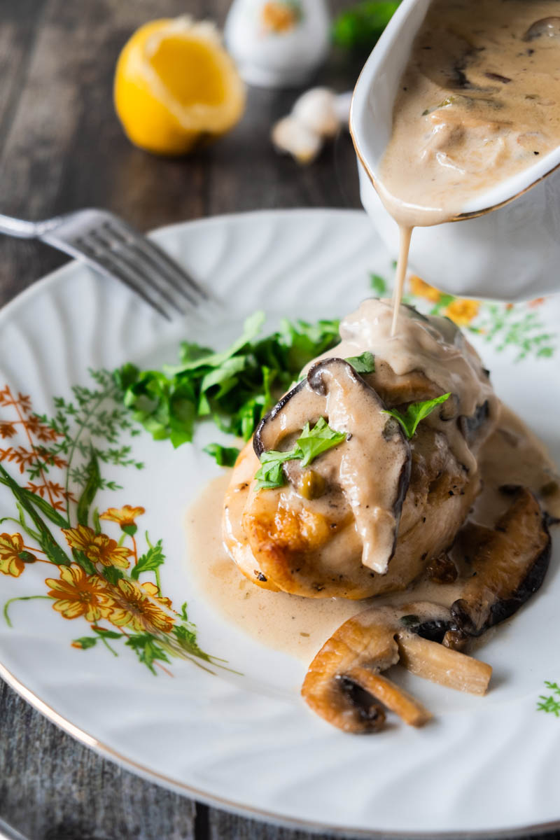 Pouring mushroom sauce on chicken.