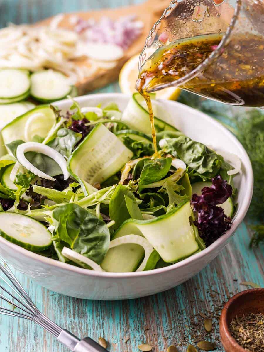 pouring blackcurrant vinaigrette onto a salad