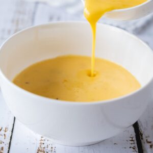 Hollandaise being poured into a Bowl.