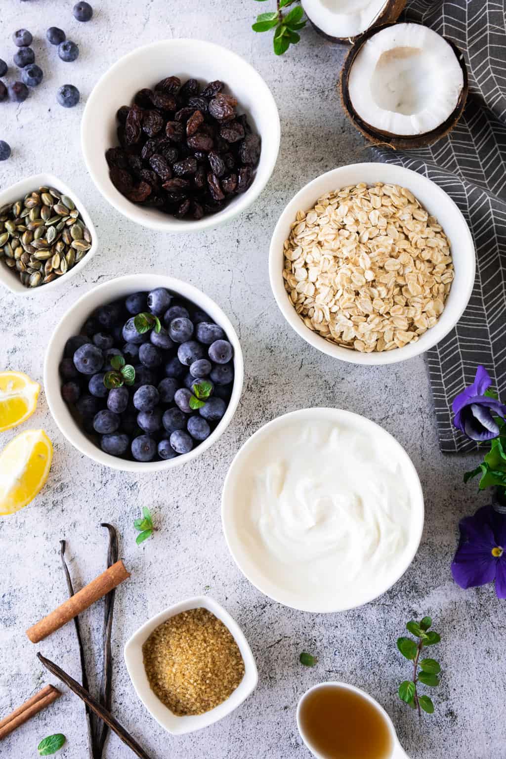 Vanilla yogurt with blueberry compote and granola ingredients.