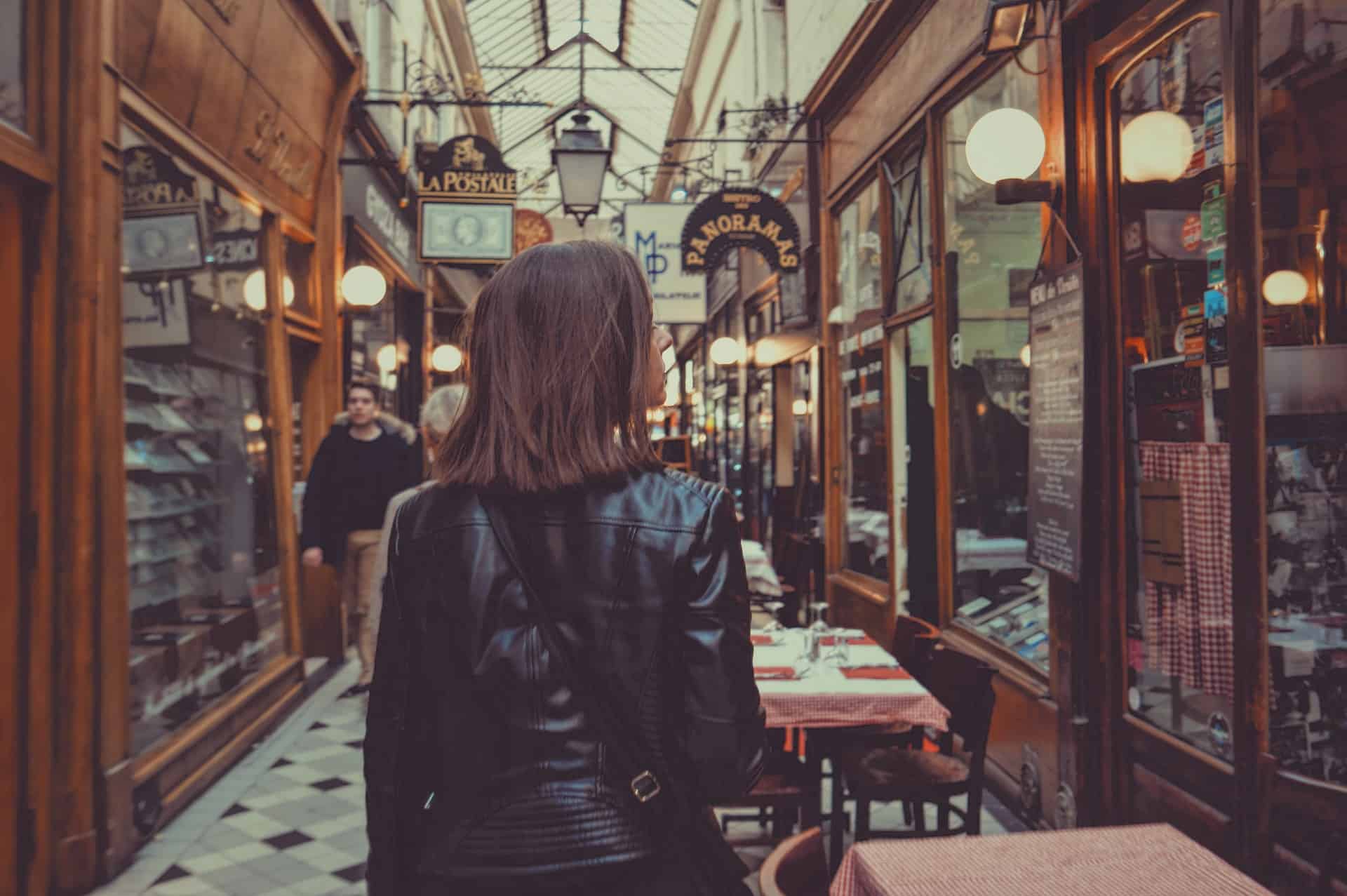 Woman walking past shops in Paris.