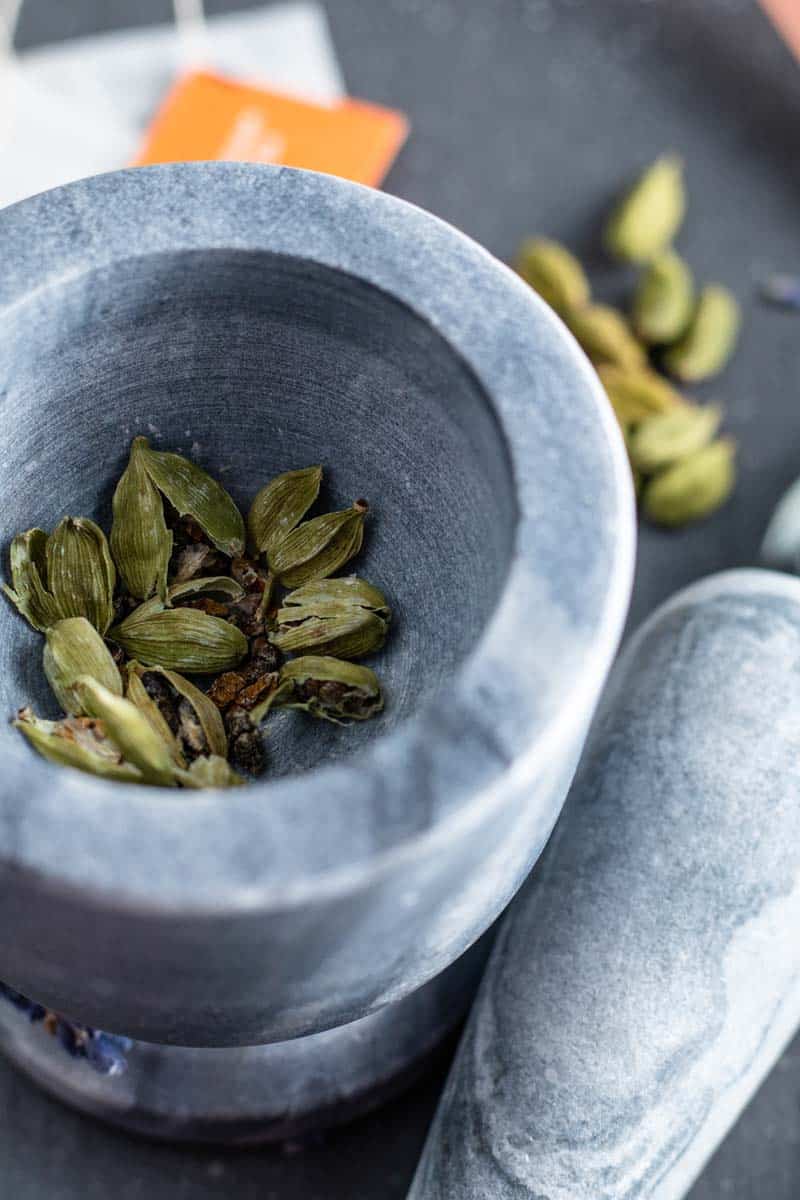 green cardamom pods in mortar