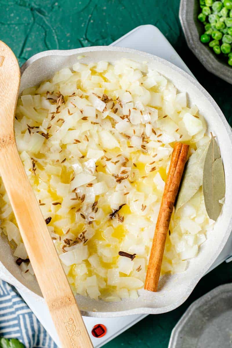 cooking onions and spices in a fry pan