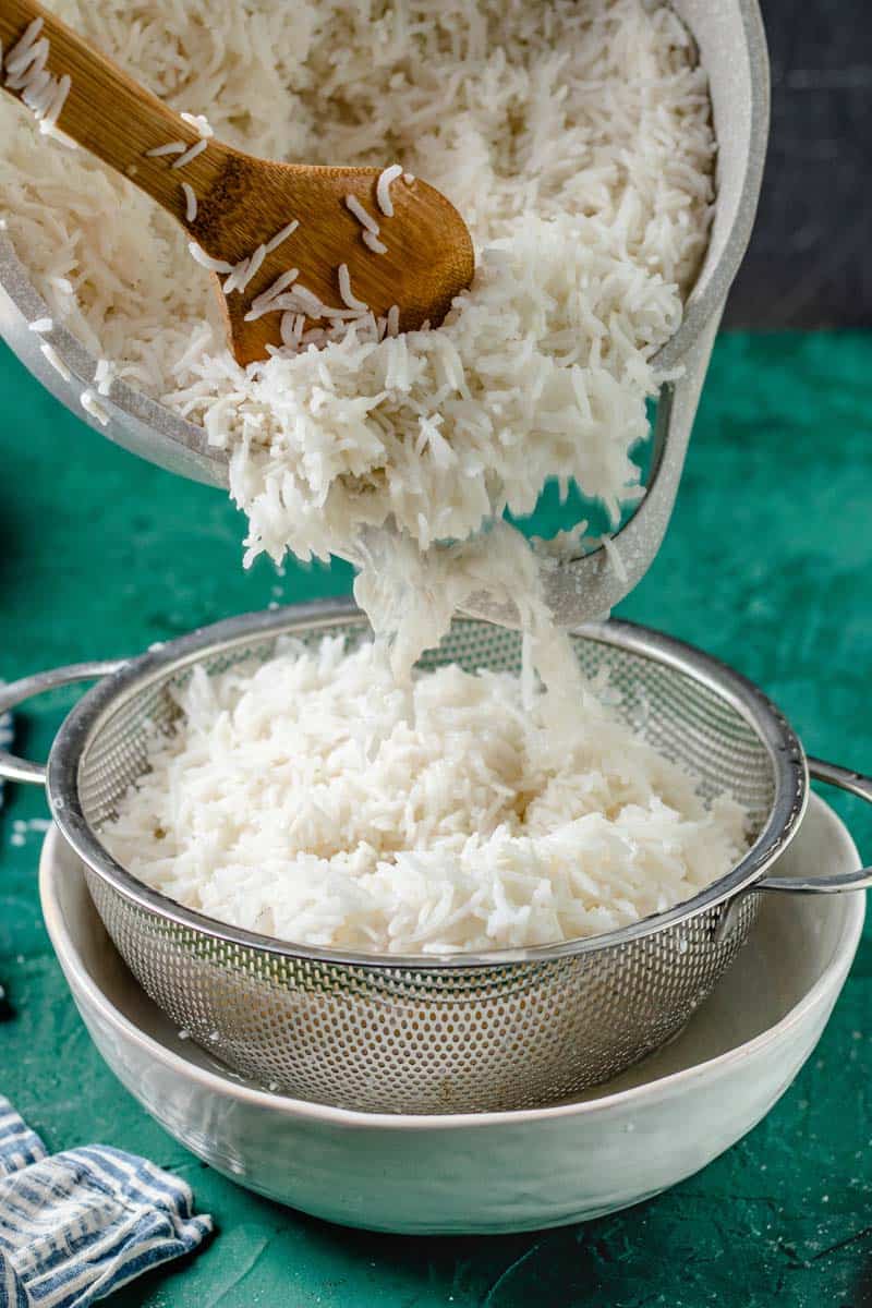 Straining cooked rice into a sieve