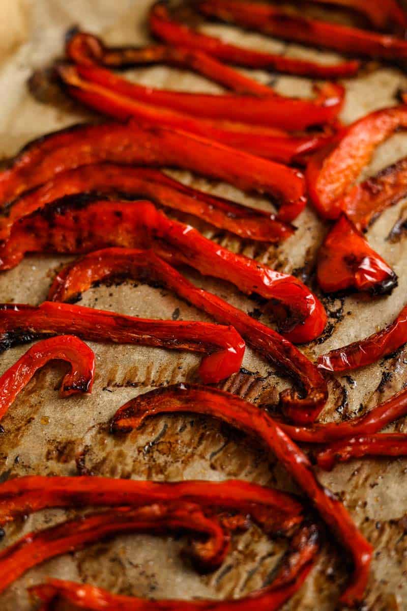 Roasted red peppers on a baking sheet after baking