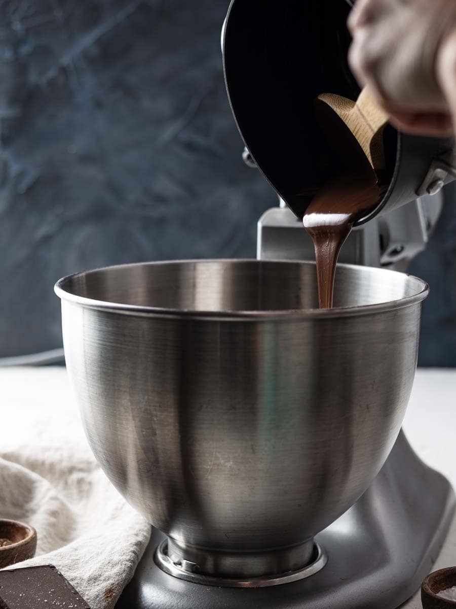 pouring melted bakers chocolate into cookie dough