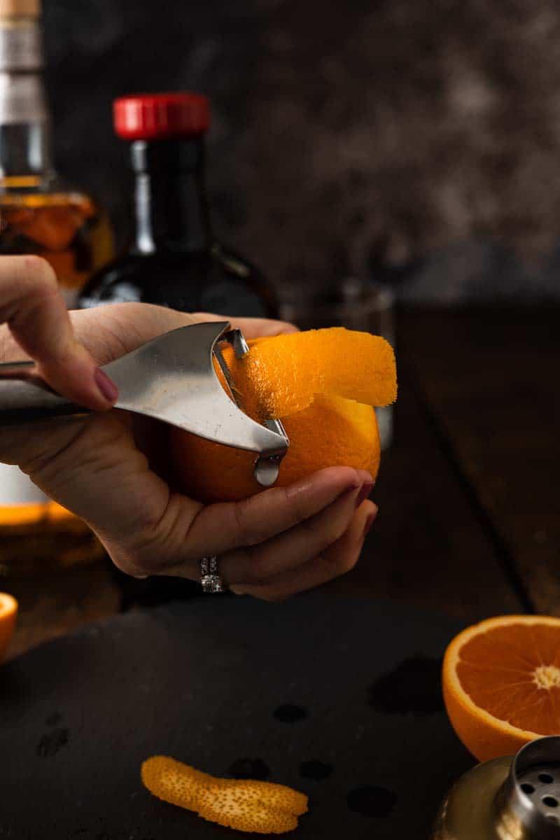 slicing an orange peel for an orange twist