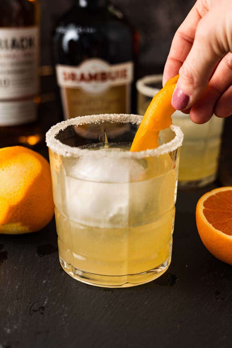 Placing an orange twist into a cocktail