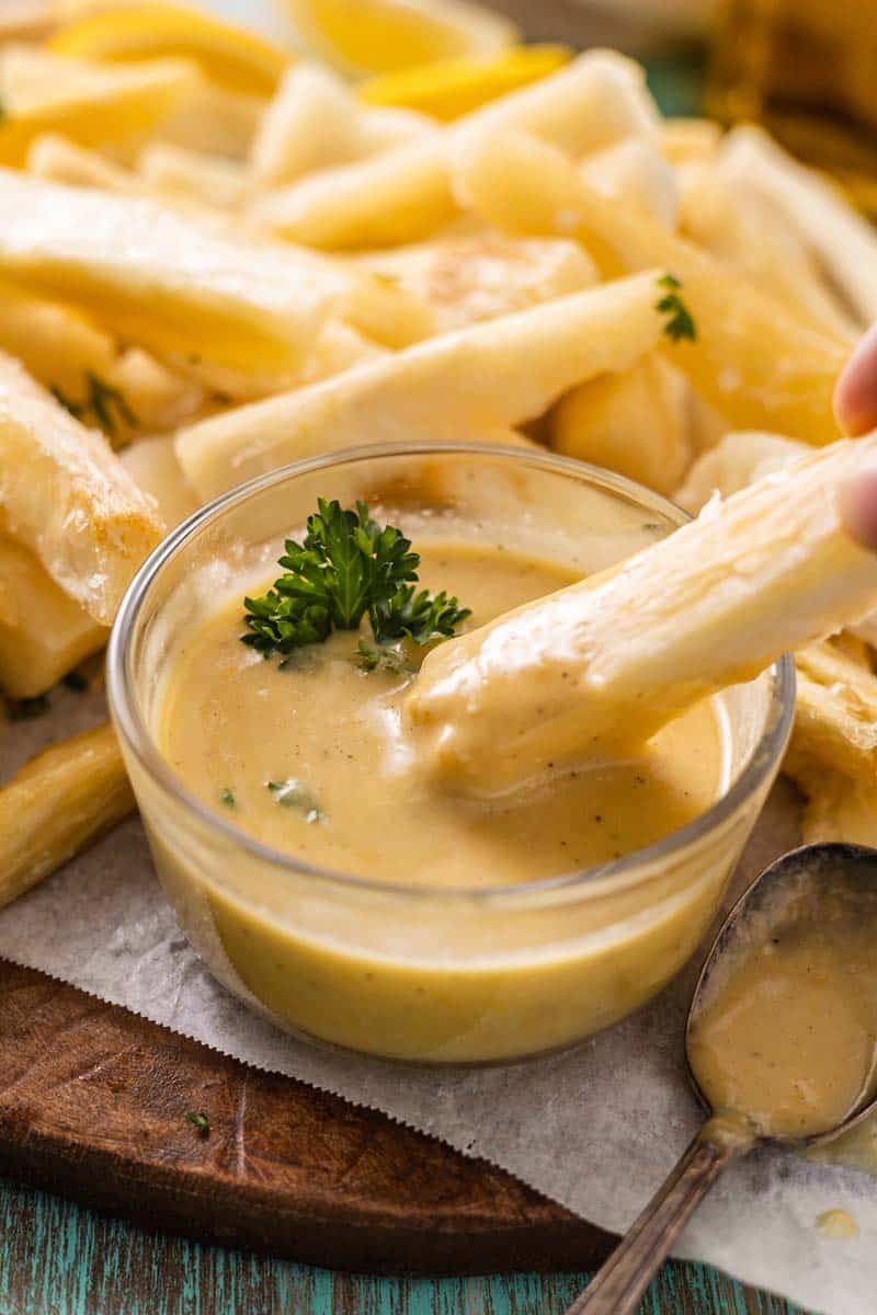 dipping a yuca fry in lemon aioli