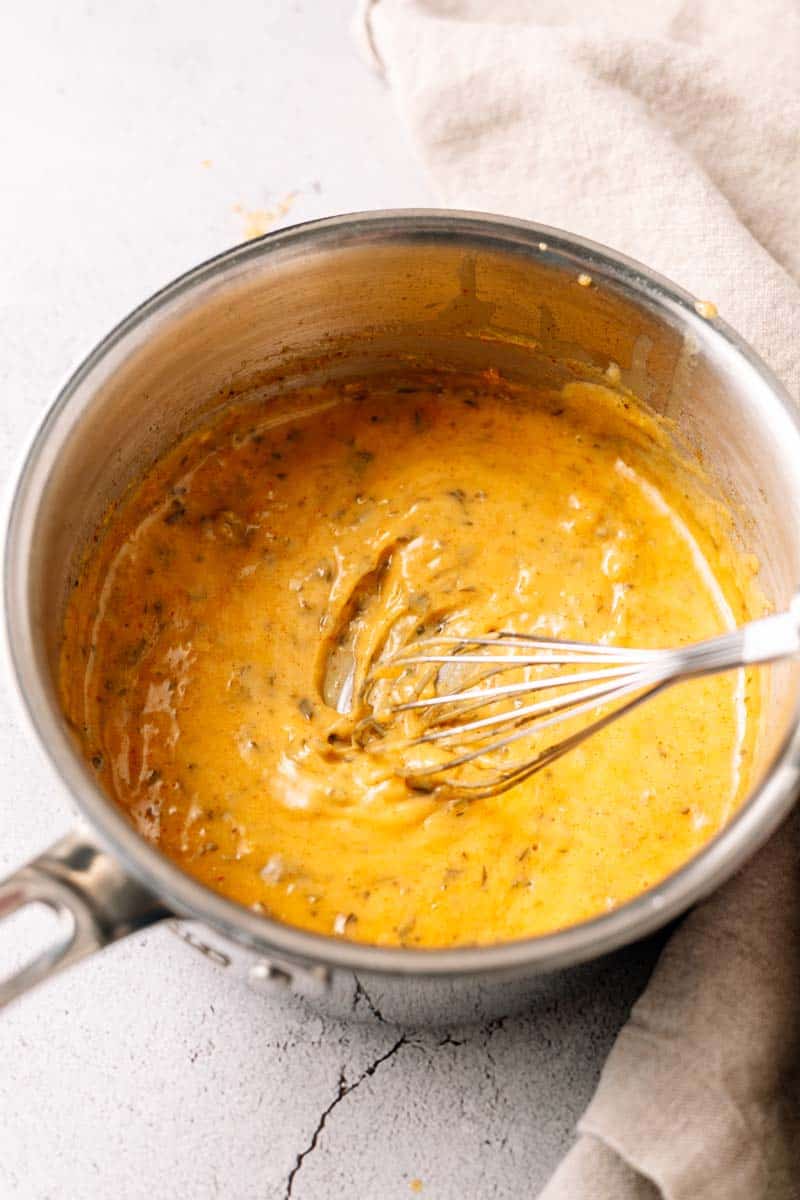 whisking a bearnaise sauce in a saucepan