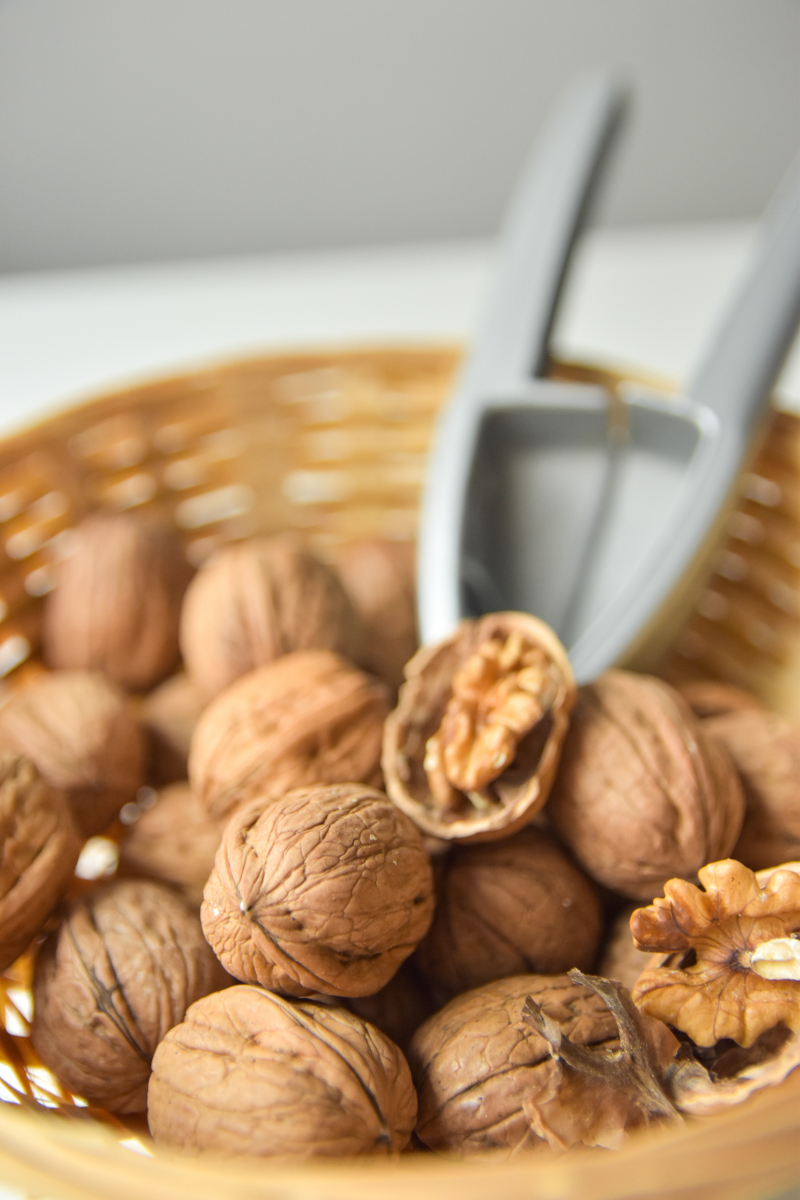 shelled and unshelled walnuts in a basket.
