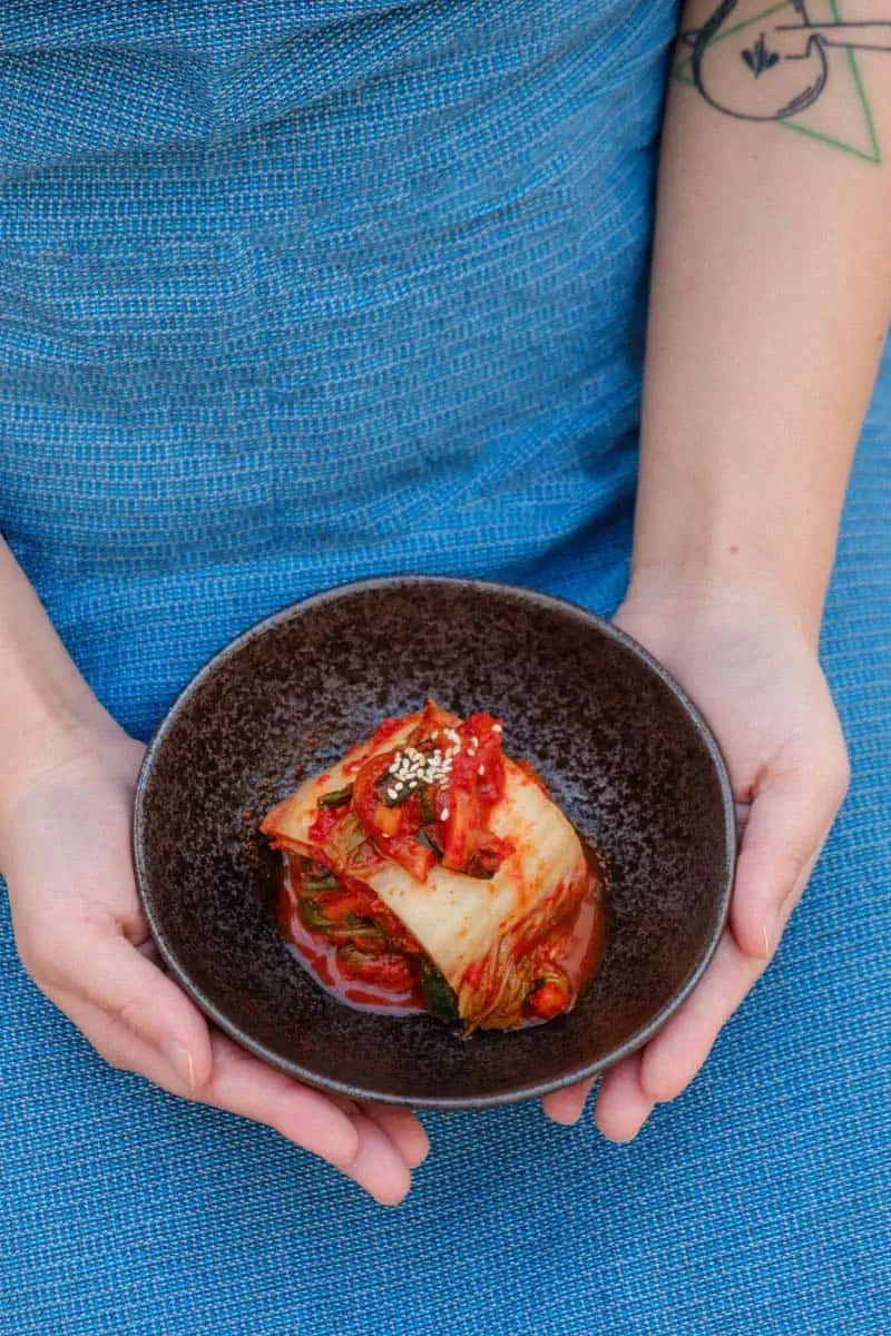 kimchi in a bowl, held by a cook.