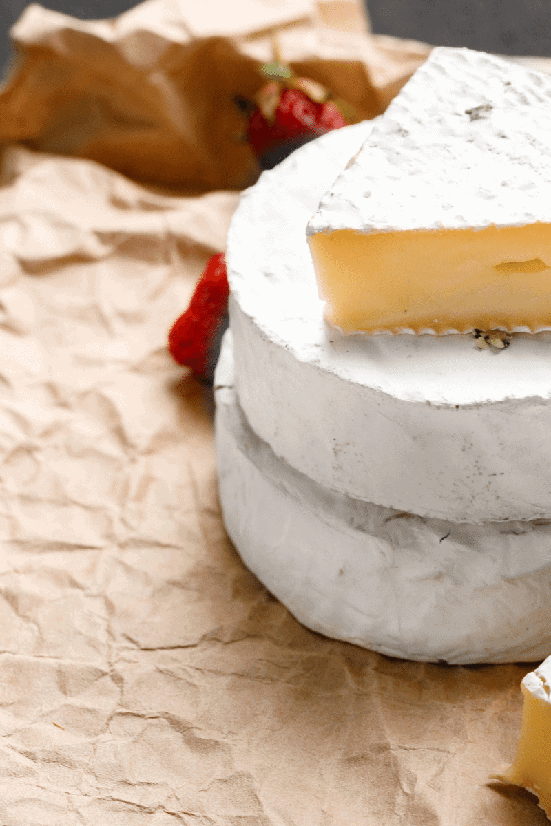 Wheel of camembert cheese on paper.