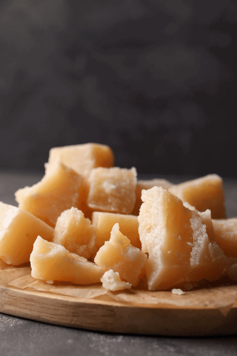 Cubes of parmigiano reggiano on a wooden board.