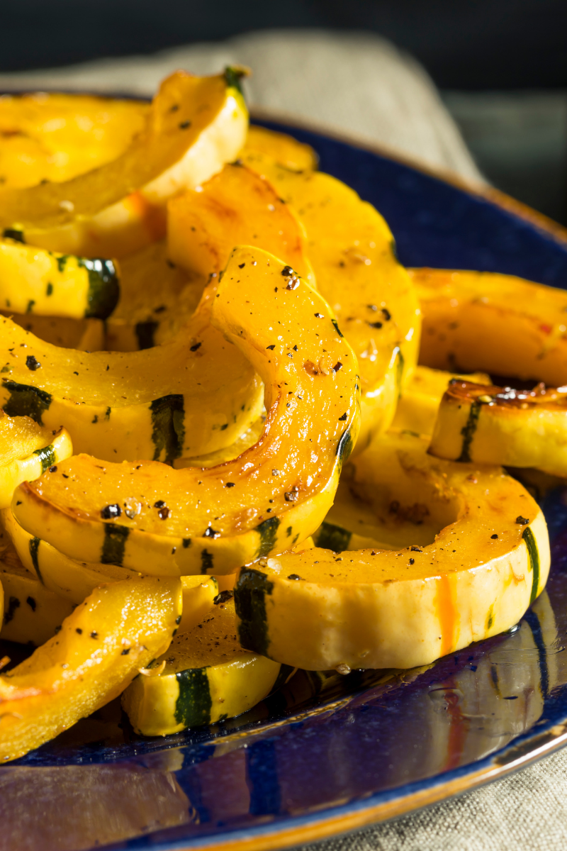 cut delicata squash on a plate.
