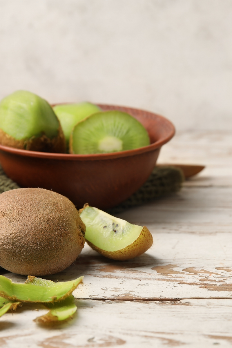whole and half kiwis, in a bowl.