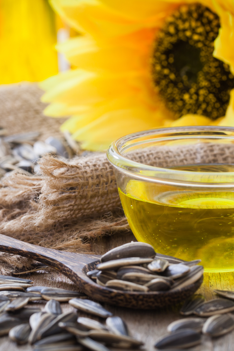 Sunflower oil in a bowl, surrounded by sunflower seeds.
