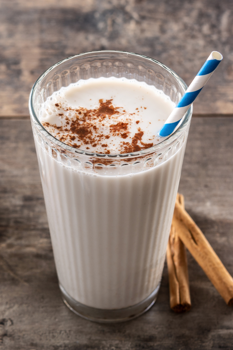 Horchata in a tall glass on a wood surface.