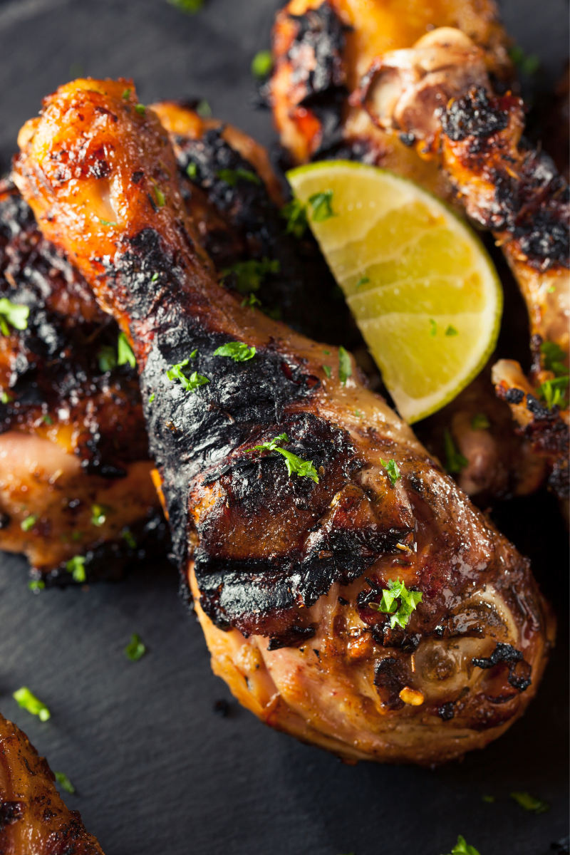 Jerk chicken on a black slate board.