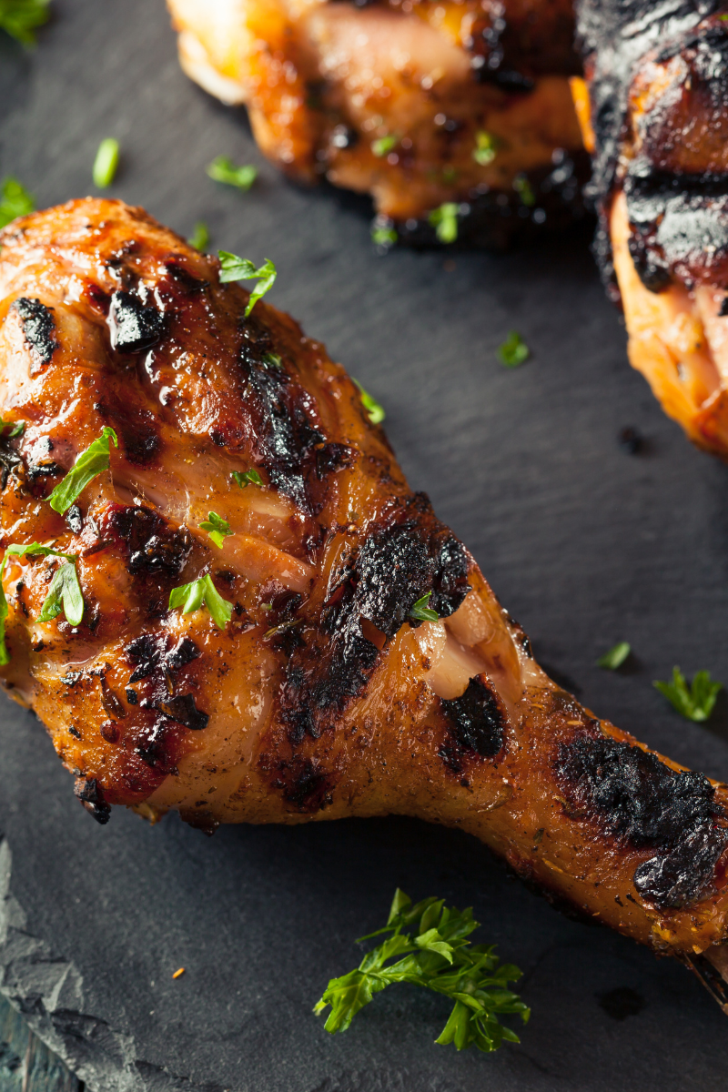 Jerk chicken on a black slate board.