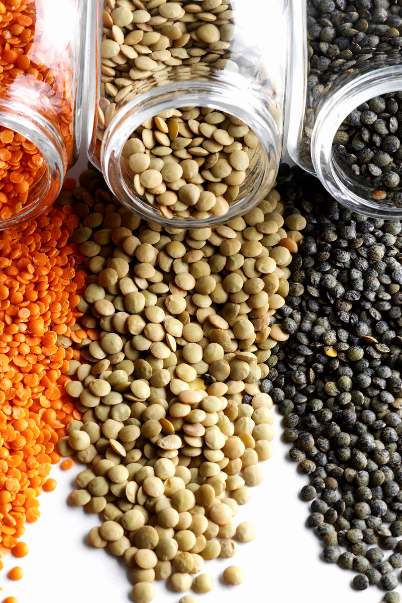 assorted lentils on a white surface.