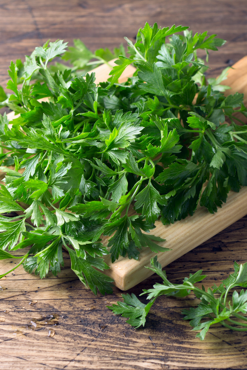 fresh parsley chopped on a cutting board.