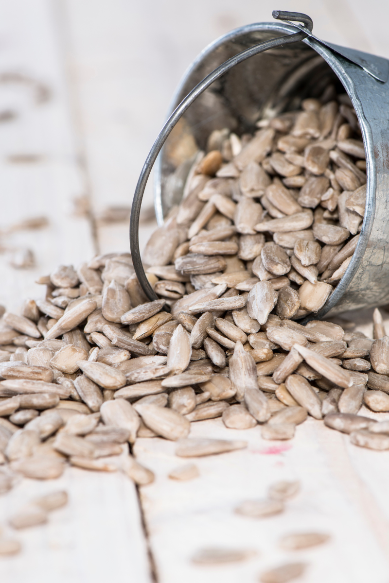 sunflower seeds on a white wood background.